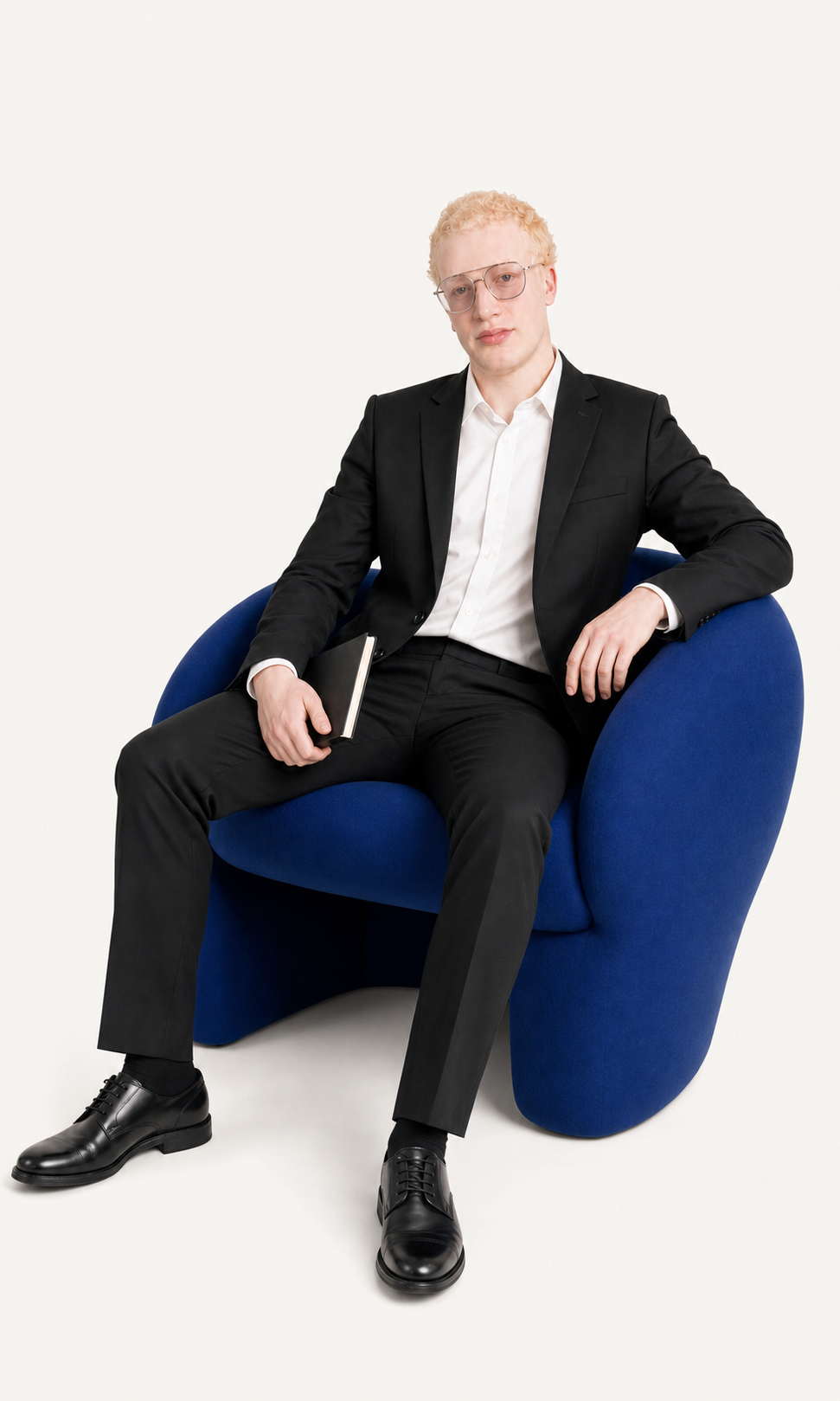 Ahmed Mansour seated in a cobalt chair